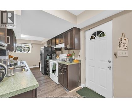 A kitchen with a sink, stove, and refrigerator.