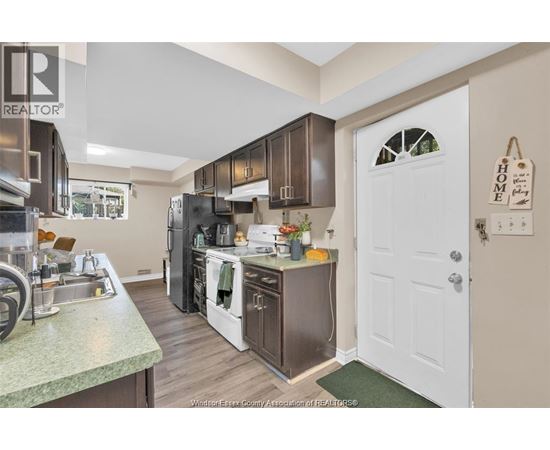 A kitchen with a sink, stove, and refrigerator.