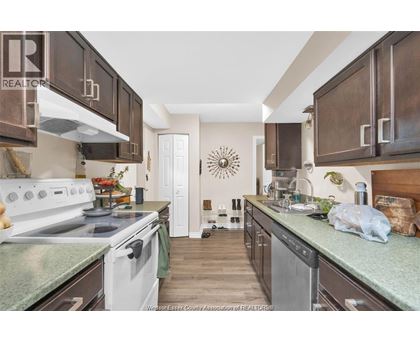 A kitchen with white appliances and brown cabinets.