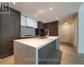 A modern kitchen with dark wood cabinets and a white island.