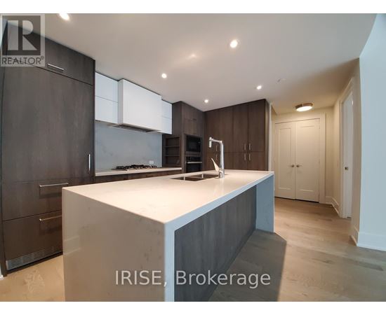 A modern kitchen with dark wood cabinets and a white island.