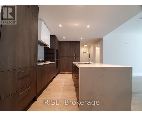 A modern kitchen with dark wood cabinets and a white countertop.