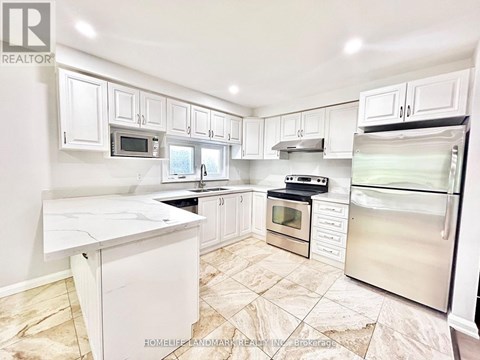 A kitchen with white cabinets and appliances.