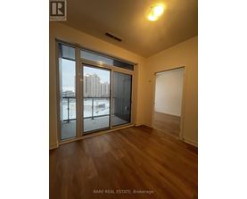 A room with a sliding glass door and wooden flooring.
