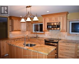 A kitchen with wooden cabinets and granite countertops.