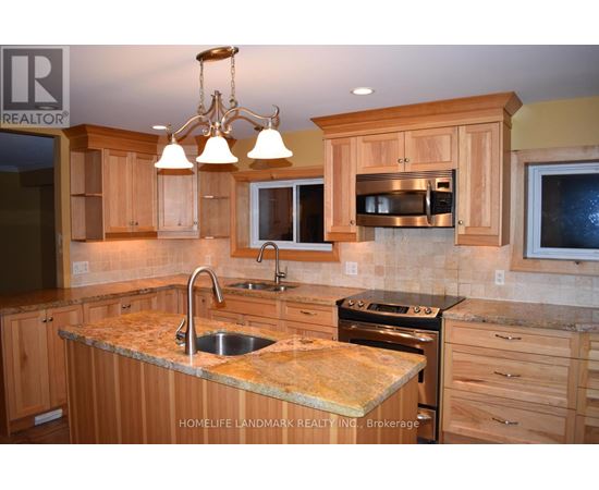 A kitchen with wooden cabinets and granite countertops.