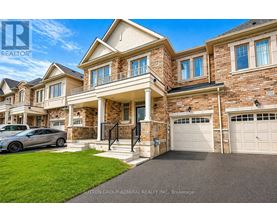 A large, luxurious house with a car parked in front.