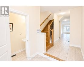 A hallway with a staircase and a toilet visible.