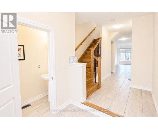 A hallway with a staircase and a toilet visible.