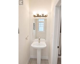 A white sink in a bathroom with a window above it.