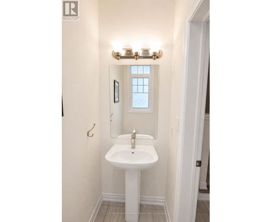 A white sink in a bathroom with a window above it.