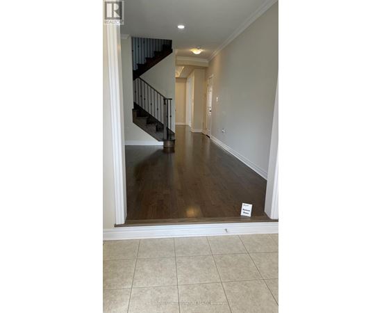 A hallway with a staircase and a sign on the floor.