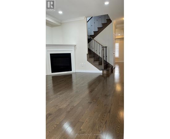 A wooden floor leads to a staircase in a home.