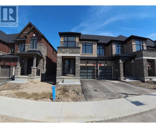 A real estate sign is displayed in front of a row of new houses.