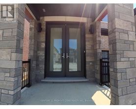 The entrance to a building with a glass door and stone pillars.