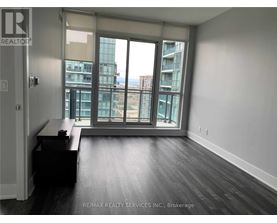 A room with a desk and a window overlooking a cityscape.