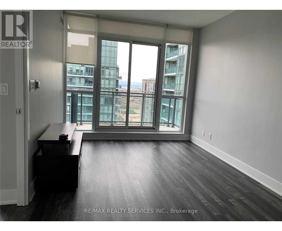 A room with a desk and a window overlooking a cityscape.