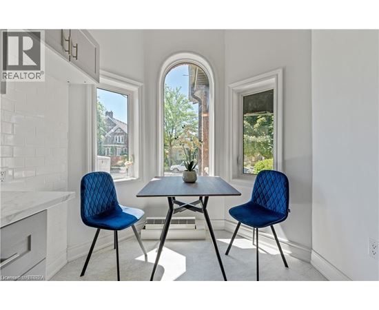 A dining room with a table and two chairs.