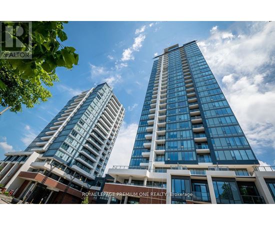 Two modern high-rise buildings with glass windows and balconies are under a blue sky with clouds.