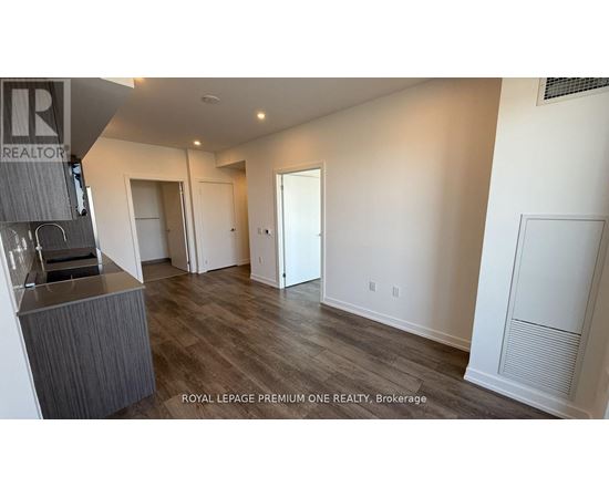 A spacious room with a bar area and a door leading to another room.