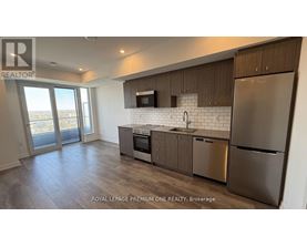 A modern kitchen with stainless steel appliances and wooden cabinets.
