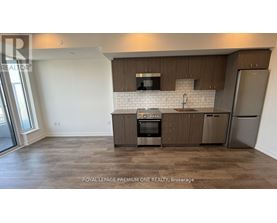 A kitchen with brown cabinets and a white backsplash.