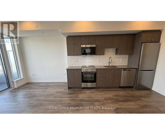 A kitchen with brown cabinets and a white backsplash.