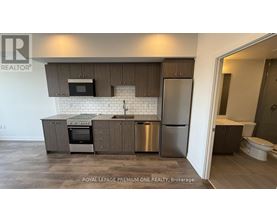 A kitchen with a refrigerator, oven, and microwave.