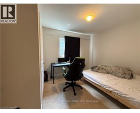 A bedroom with a bed, desk, and chair.