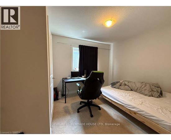 A bedroom with a bed, desk, and chair.