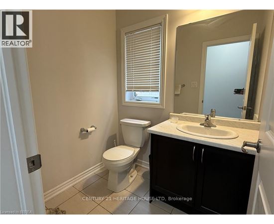 A bathroom with a toilet, sink, and window.