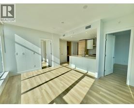 A spacious room with wooden flooring and white walls.