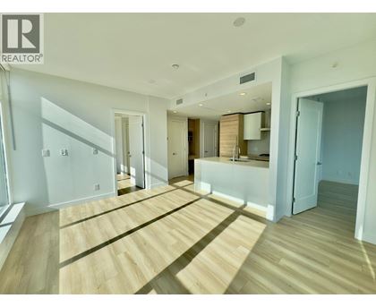 A spacious room with wooden flooring and white walls.