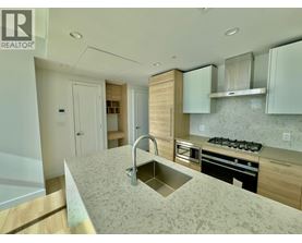 A modern kitchen with a sink, stove, and cabinets.