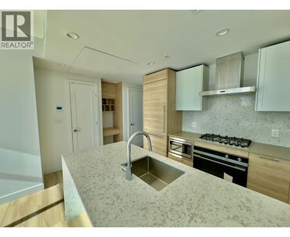 A modern kitchen with a sink, stove, and cabinets.