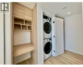 A laundry room with a washer and dryer built into a cabinet.
