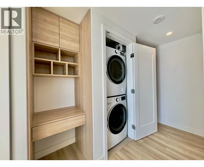 A laundry room with a washer and dryer built into a cabinet.