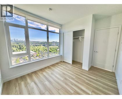 A room with a large window overlooking a cityscape.