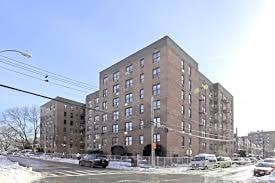 A large brick building with a parking lot in front of it.