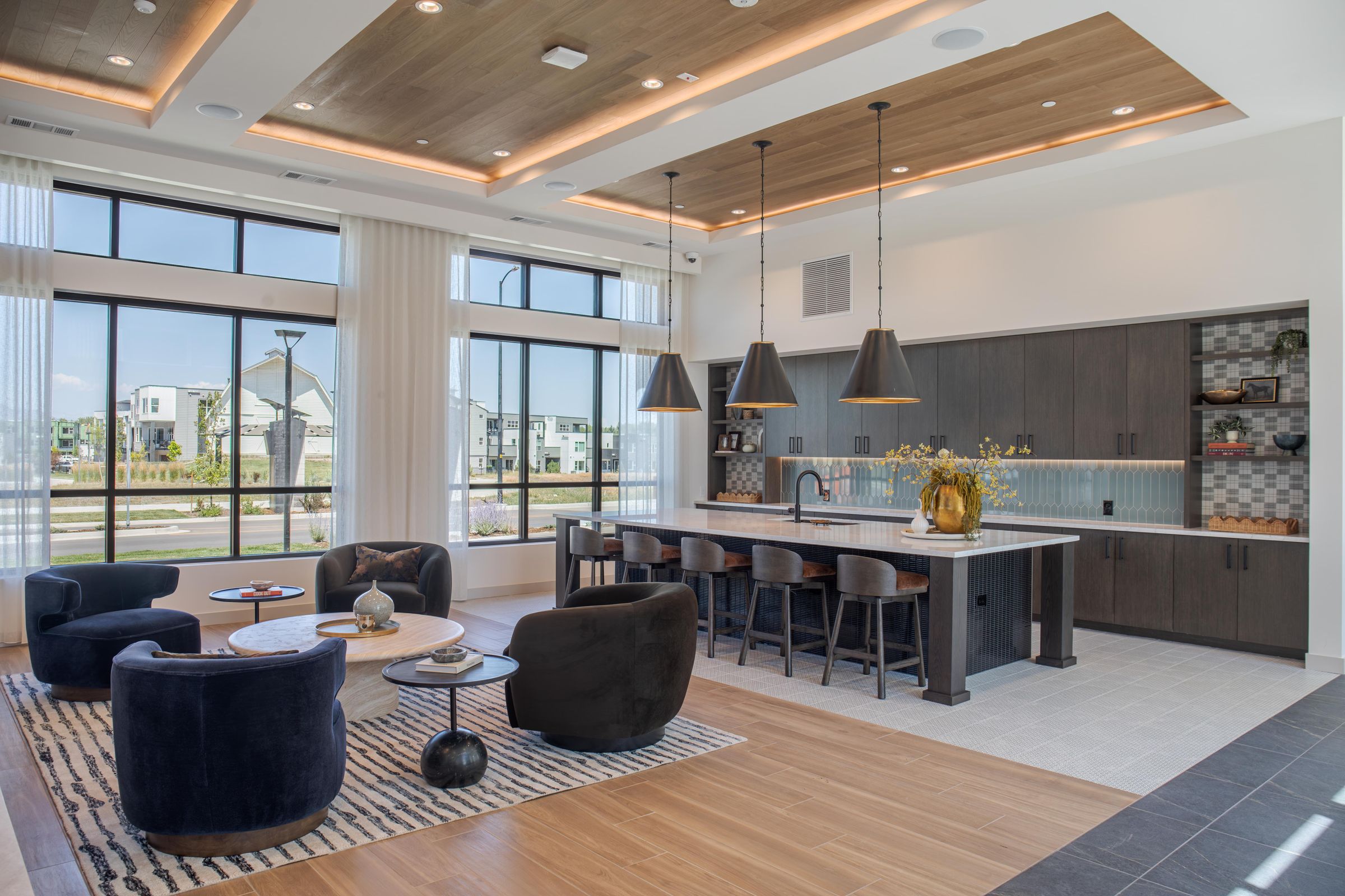 A modern kitchen and living room with a large island and lots of seating.