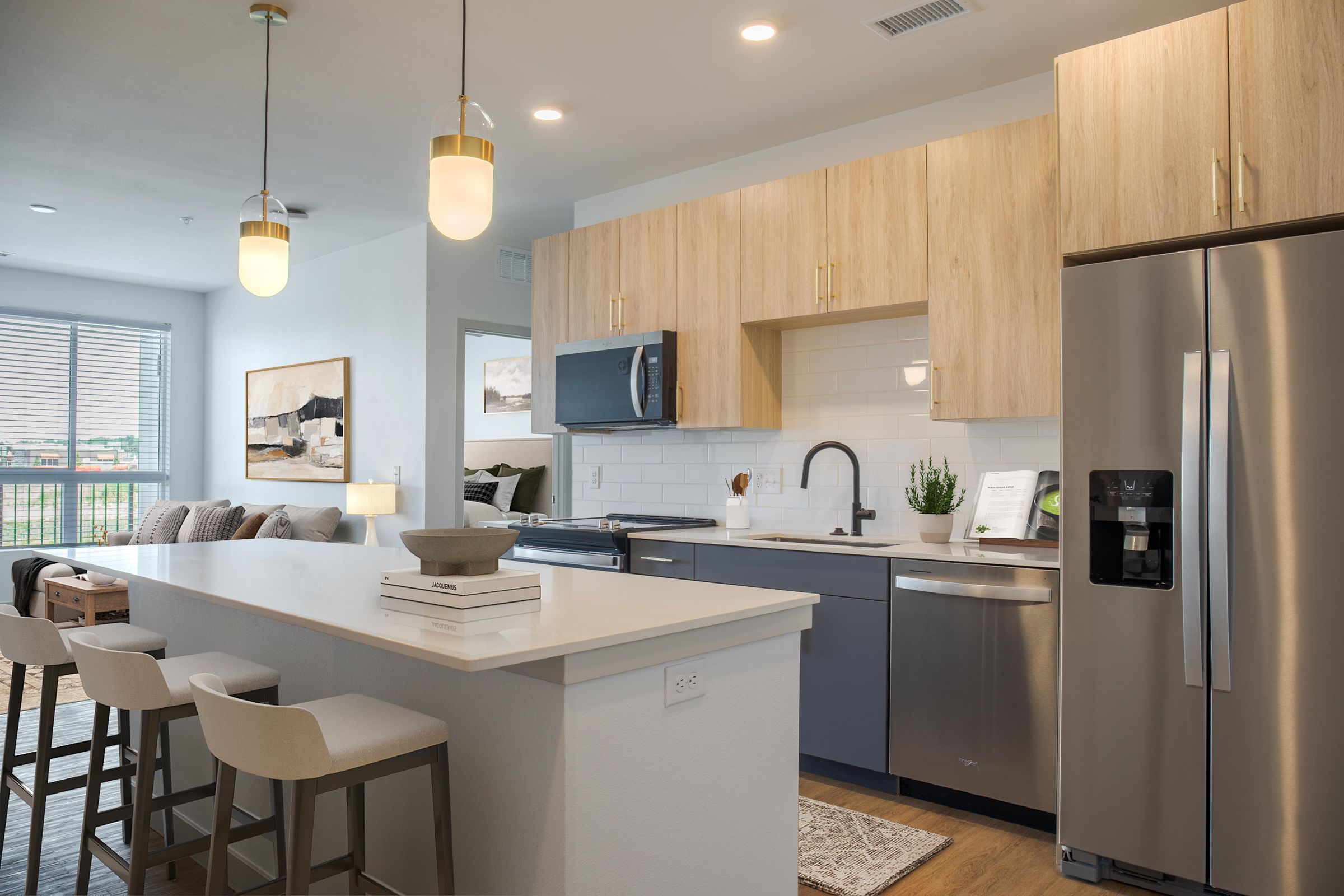 A modern kitchen with a white countertop and stainless steel appliances.