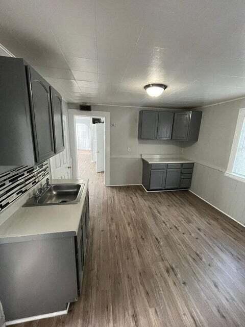 A kitchen with a sink and a refrigerator.