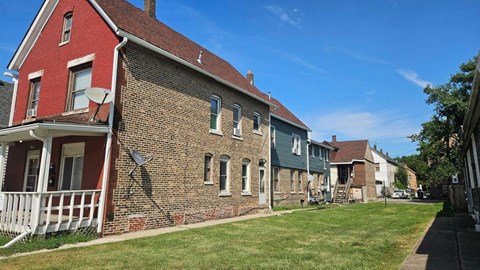 A row of houses with a red brick house on the left.