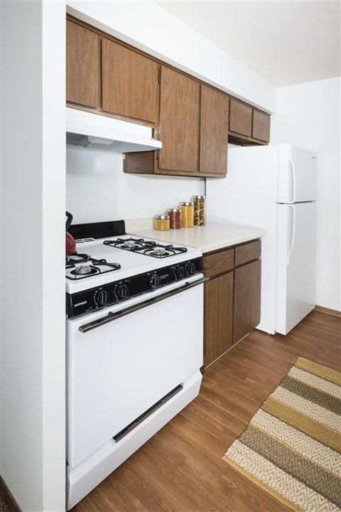 A white stove in a kitchen with wooden cabinets.