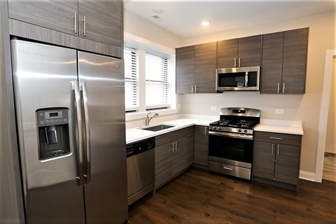 A modern kitchen with a stainless steel refrigerator and wooden cabinets.