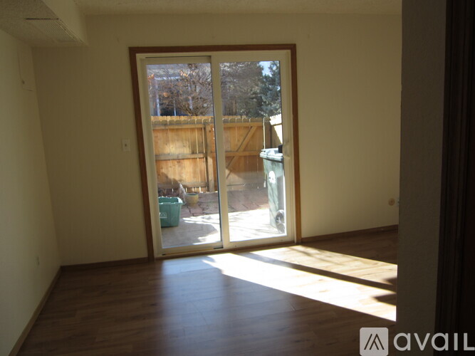 A room with a sliding glass door leading to a backyard.