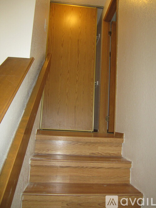 A wooden staircase with a door at the top.