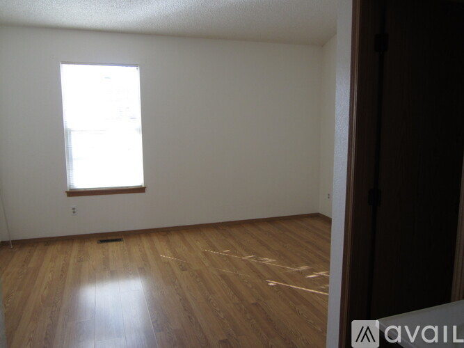 A room with wooden flooring and a window.