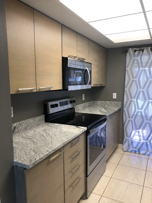 A kitchen with a granite countertop and stainless steel appliances.