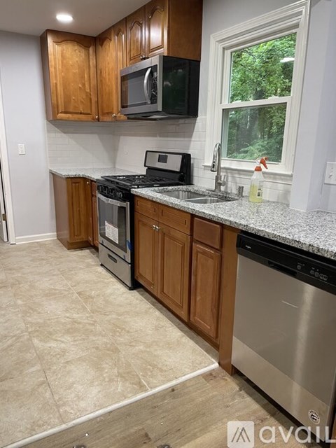 A kitchen with wooden cabinets and a granite countertop.